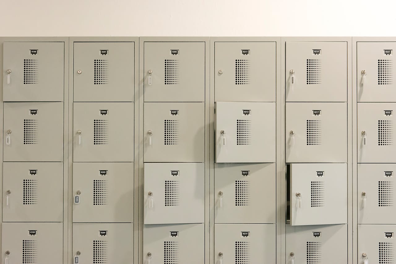 A row of grey metal lockers indoors with some doors ajar.